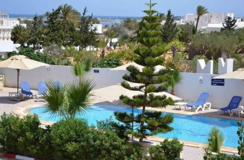 een resort met een zwembad en een dennenboom bij Love in Midoun