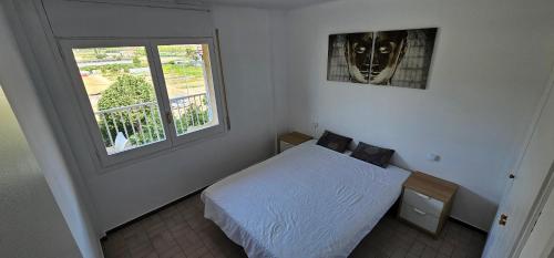 - une chambre dotée d'un lit avec un masque mural dans l'établissement Apartamento con gran piscina y frente a la playa., à Malgrat de Mar
