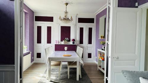 une salle à manger avec une table blanche et des murs violets dans l'établissement Maison Carpe HORAM proche de la mer, à Cayeux-sur-Mer