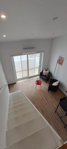 a living room with a staircase and a red chair at Tomarhousing - Templar in Tomar