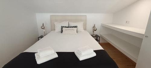 a bedroom with a large white bed with two pillows at Tomarhousing - Templar in Tomar