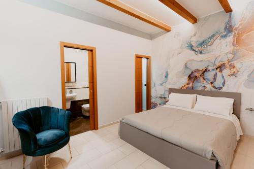 sypialnia z łóżkiem i niebieskim krzesłem w obiekcie Dimora L'Etual w mieście Bari