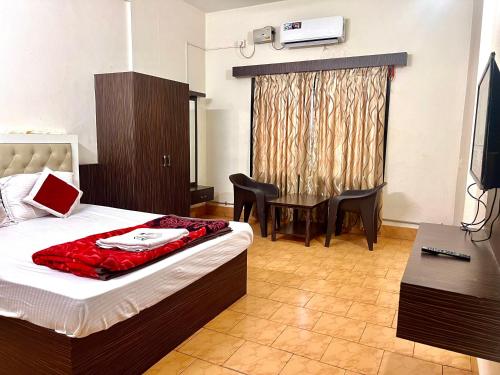 Un pat sau paturi într-o cameră la Hotel Manasa