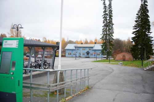 a gas pump at a bus stop with a building at Liekorannan Majatalo- kodinomaista majoitusta rautatieasemaa vastapäätä in Sastamala