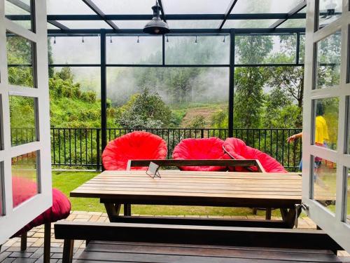 a screened in porch with a red couch and a table at Jayawardane’s Bungalow in Mandaramnuwara in Mandaran Newara