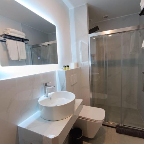a white bathroom with a sink and a shower at Celia Residence in Athens