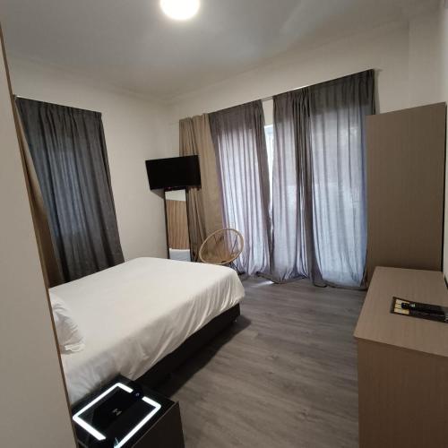a hotel room with a bed and two windows at Celia Residence in Athens