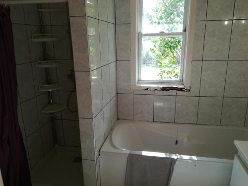 een badkamer met een bad en een raam bij Notre nid d'amour in Saint-Sernin-du-Bois