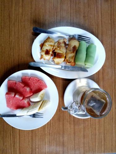 drie borden eten op een tafel met fruit bij Nadya Homestay in Munduk
