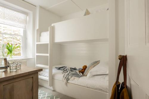 ein weißes Schlafzimmer mit einem Etagenbett darin in der Unterkunft 21 Island Street in Salcombe