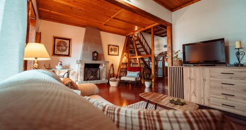 a person laying on a couch in a living room with a fireplace at Charming Holiday House - House & Apartment in Biscoitos
