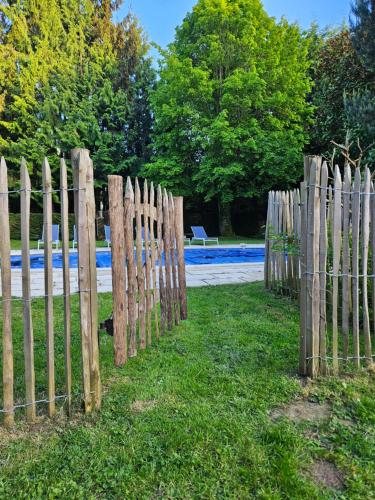 une clôture en bois dans l'herbe à côté d'une route dans l'établissement Authentique Maison Normande avec Piscine, à Tourgéville
