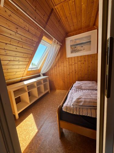 a small room with a bed in a wooden cabin at Domki wczasowe OSKAR in Chłopy