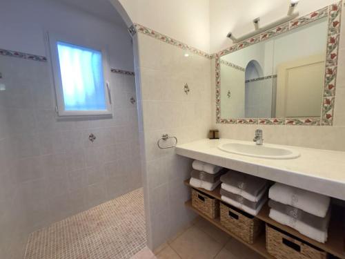 une salle de bain avec un lavabo, un miroir et une douche dans l'établissement 72 m2 Centre-ville avec jardin, à Porto-Vecchio