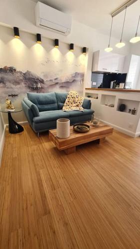 un salon avec un canapé bleu et une table basse dans l'établissement Appartement Ajaccio proche plage, à Ajaccio