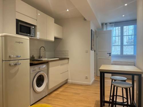 une cuisine avec lave-linge, sèche-linge et une table dans l'établissement Chez Bénédicte, à Montpellier