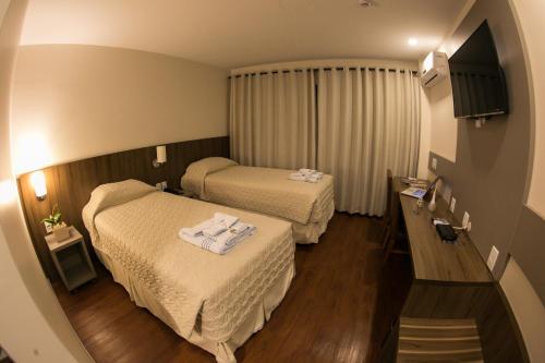 um quarto de hotel com duas camas com toalhas em Hotel Dom Rafael Premium em Santa Maria