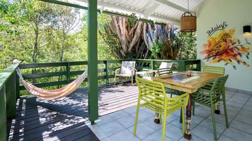 een patio met een hangmat en een houten tafel en stoelen bij Dream of the Green Flamingo in Willibrordus