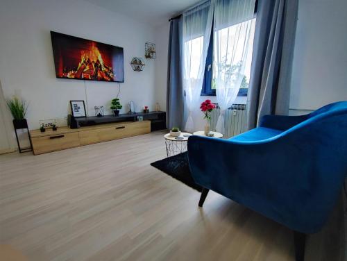a living room with a blue couch and a tv at Apartman Luxe Victoria in Zagreb