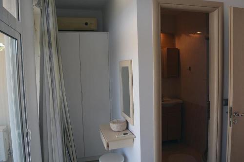 a white bathroom with a sink and a mirror at Luxury house Makry gialos 200m to the beach 6 pers in Makry Gialos