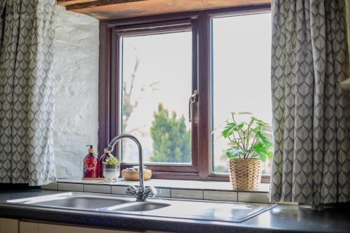a kitchen sink with a window in a kitchen at West Hollowcombe Farm in Dulverton