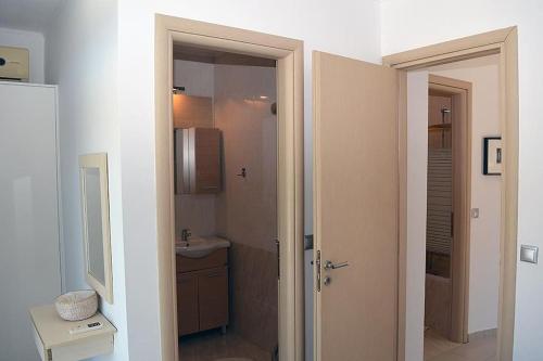 a bathroom with a sink and a toilet and a mirror at Luxury house Makry gialos 200m to the beach 6 pers in Makry Gialos