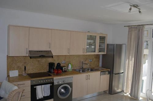 a kitchen with a sink and a refrigerator at Luxury house Makry gialos 200m to the beach 6 pers in Makry Gialos