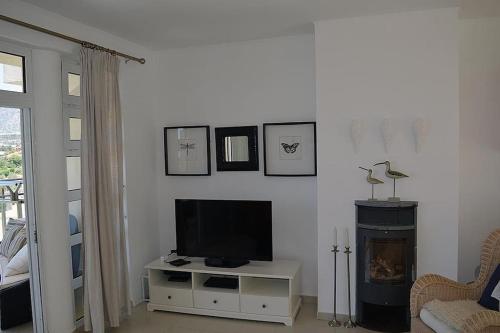 a living room with a television and a fireplace at Luxury house Makry gialos 200m to the beach 6 pers in Makry Gialos