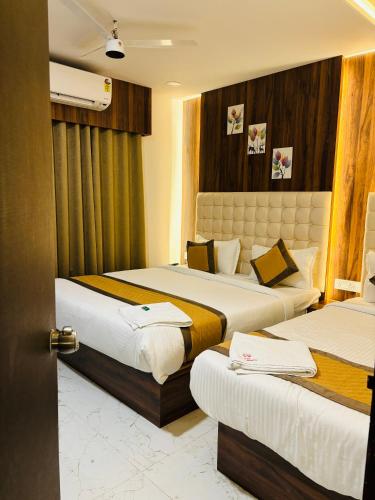 a hotel room with two beds in a room at Airport Hotel Relax Inn in Nagpur