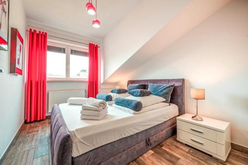 a bedroom with a large bed with red curtains at Perugia Moxy TE&AM Cracow in Krakow