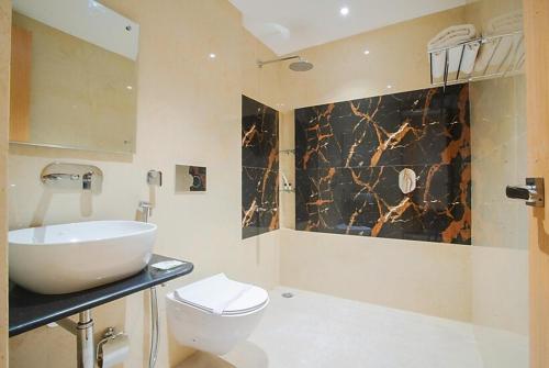 a bathroom with a sink and a toilet at Hotel Classic in Lucknow