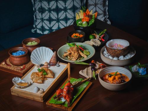 a table topped with plates of food and bowls of food at Hyatt Regency Koh Samui in Chaweng