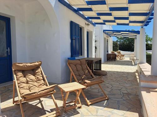 two chairs and a table on a patio at Iremia North Kokkali Beach Leros in Gourna