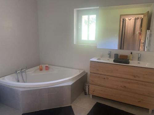 La salle de bains est pourvue d'une grande baignoire et d'un lavabo. dans l'établissement Mas avec piscine entre Alpilles et Luberon, à Sénas
