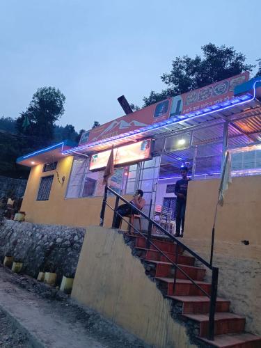 Ein Mann stand nachts vor einem Restaurant. in der Unterkunft Hotel Mount Kailash in Gupta Kāshi