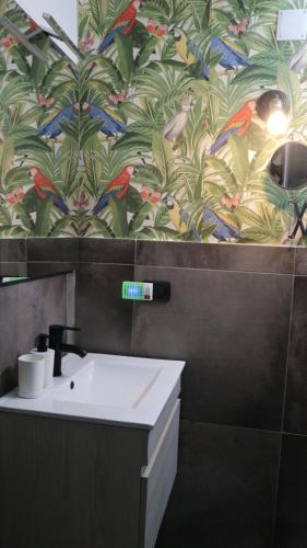 a bathroom with a sink and a colorful wallpaper at Napoli in Villa in Naples
