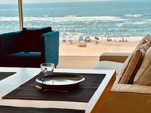 a table with a plate and a view of the beach at Villa vue imprenable sur l’Océan. in Moulay Bousselham