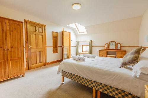 a bedroom with a large bed and a wooden door at Courtyard Cottage in Tomich