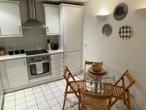 cocina con mesa de cristal y 2 sillas en CoZZy 1-Bed Apartment in Liverpool St & Shoreditch, en Londres