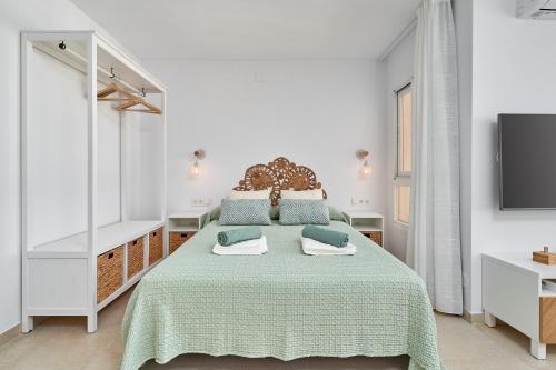 a white bedroom with a bed and a tv at Kanu Apartment - Torrox Costa in Torrox Costa