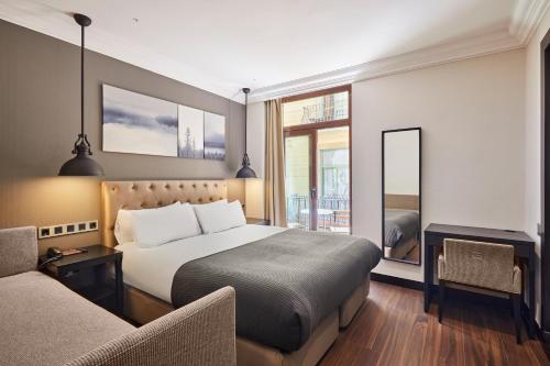 una habitación de hotel con una cama y una silla en Hotel Cortes Rambla, en Barcelona