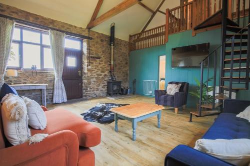uma sala de estar com dois sofás e uma mesa em West Hollowcombe Farm em Dulverton