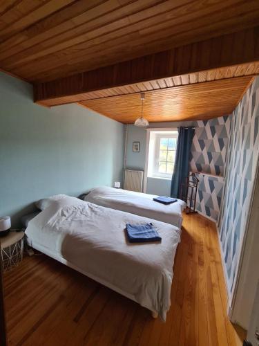 une chambre avec deux lits et un plafond en bois dans l'établissement Le Jardin de Chignore, à Vollore-Ville