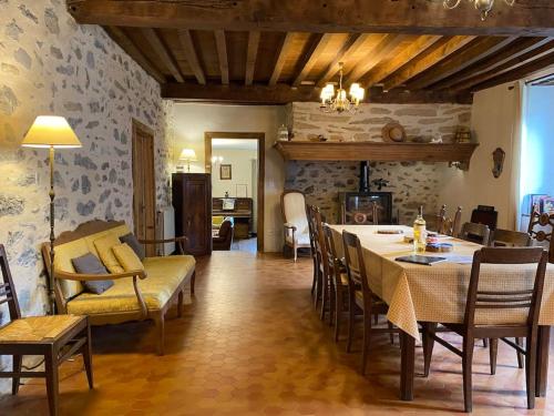 een eetkamer met een tafel en stoelen en een woonkamer bij Chez Jeanne, superbe corps de ferme, vue imprenable in Issor