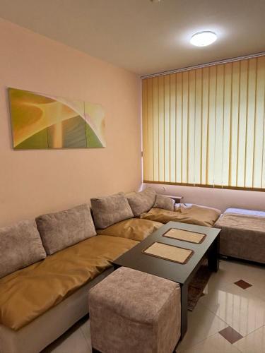 a living room with a couch and a table at Студио Бургас 2 in Burgas