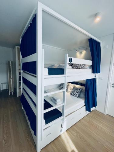 a white bunk bed with blue and white shelves at Partenope Hostel and Suites in Angra do Heroísmo