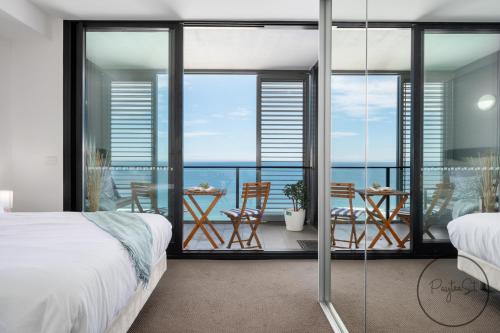 um quarto com uma varanda com vista para o oceano em Beachfront Beauty - Wifi Included em Newcastle