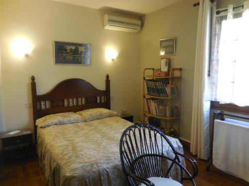 ein Schlafzimmer mit einem Bett und einem Stuhl darin in der Unterkunft La Madriguera Accommodation in Gardes-le-Pontaroux