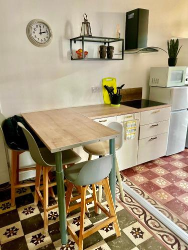 une cuisine avec une table et des chaises en bois dans l'établissement Charmant appartement, à Nîmes
