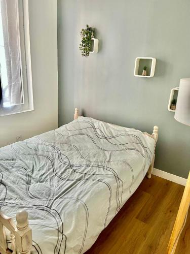 une chambre avec un lit avec une couverture dessus dans l'établissement Charmant appartement, à Nîmes